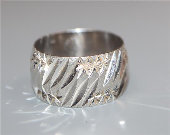 An 18ct white gold bright cut engraved modernist wedding band, size P/Q.